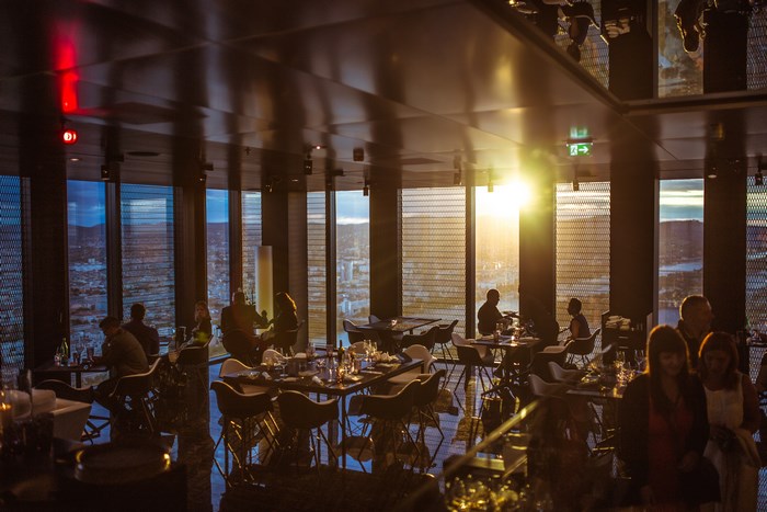 Restaurant interior with sunset view and people dining