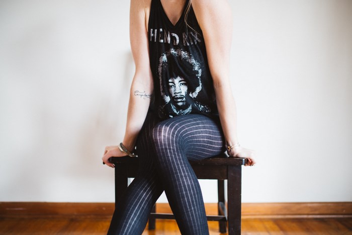 Woman in Hendrix t-shirt sitting on a stool