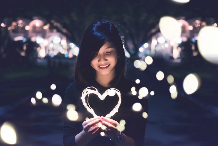 Smiling Asian Woman with Heart-Shaped Bokeh Lights