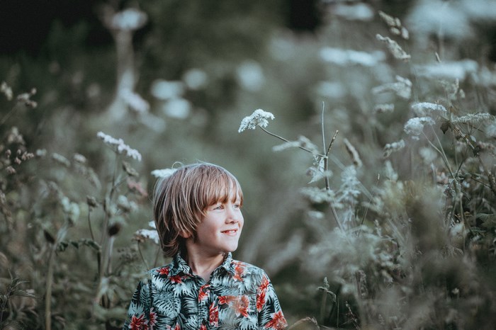 Boy in a floral shirt in a field