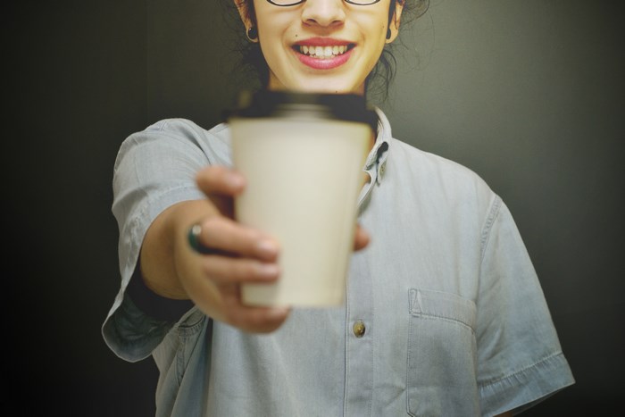 Woman offering a coffee cup