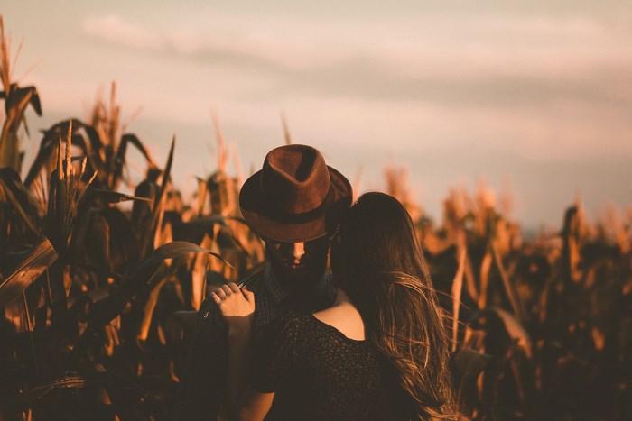 Couple Embracing in a Cornfield at Sunset