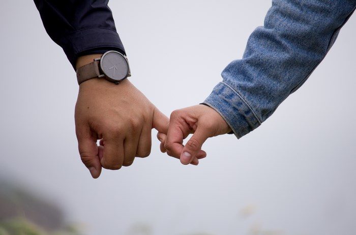 Couple holding hands with a watch