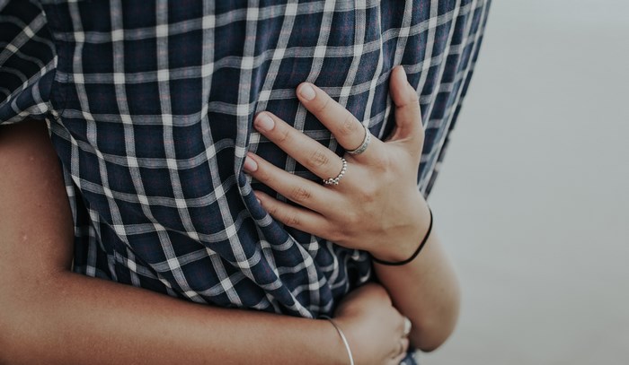 Couple hugging with plaid shirt and rings