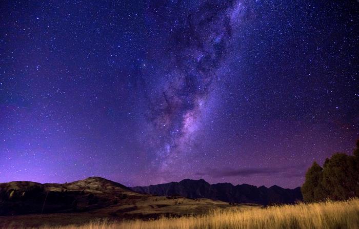 Milky Way Galaxy over Mountains and Grasslands at Night