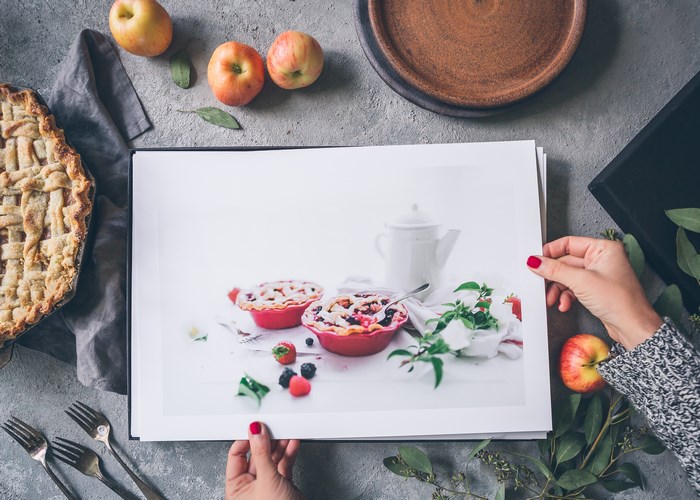 Woman holding a portfolio with berry pies and apples