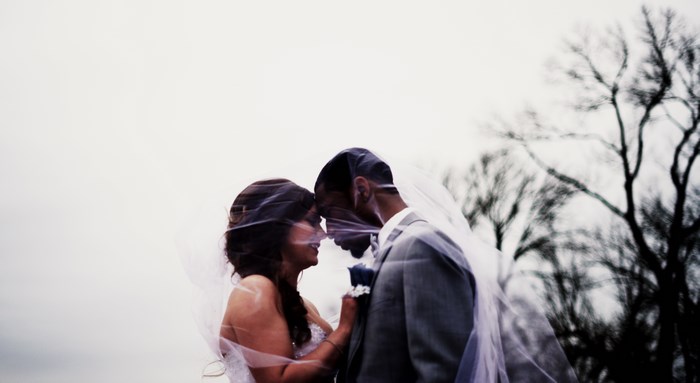 Interracial Bride and Groom Embrace Outdoors