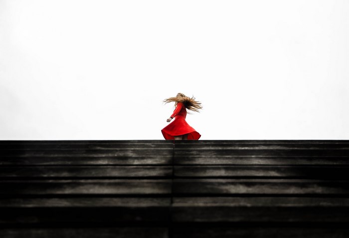 Woman in red dress twirling on stairs