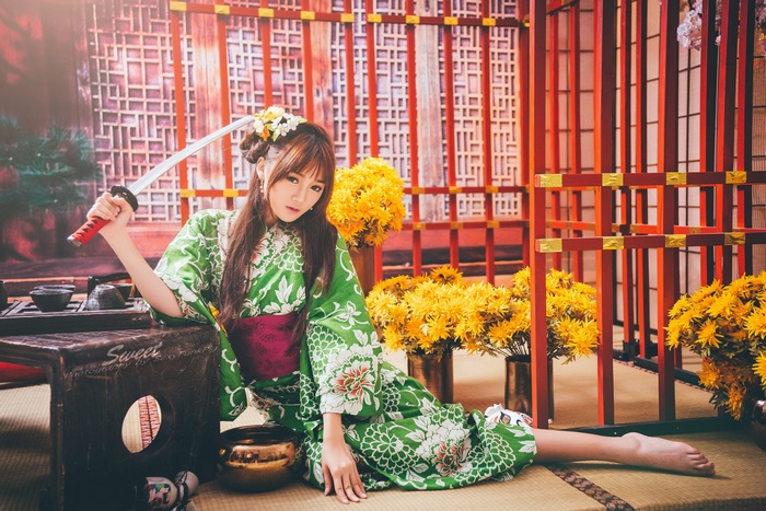 Woman in Green Kimono with Sword and Yellow Flowers