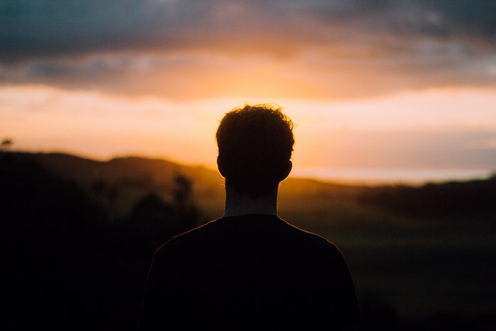Man silhouetted against a New Zealand sunrise