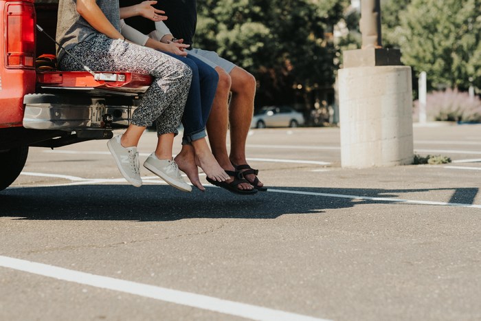 People sitting on the tailgate of a red truck