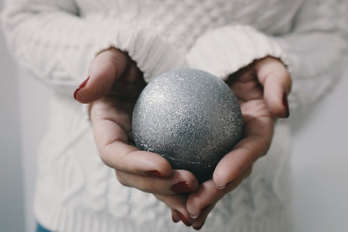 Hands Holding Sparkling Grey Christmas Ornament