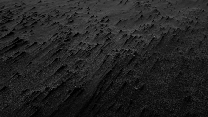 Black sand dunes with wind patterns