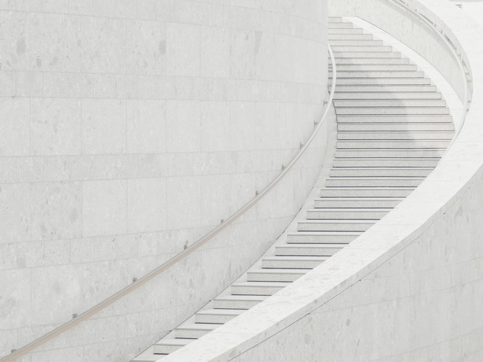 Curved white stone staircase with handrail in Germany