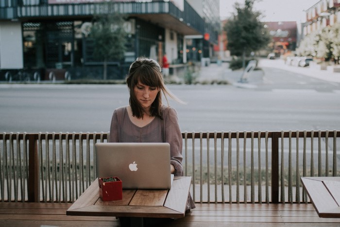 Woman working on a laptop at an outdoor cafe in Austin