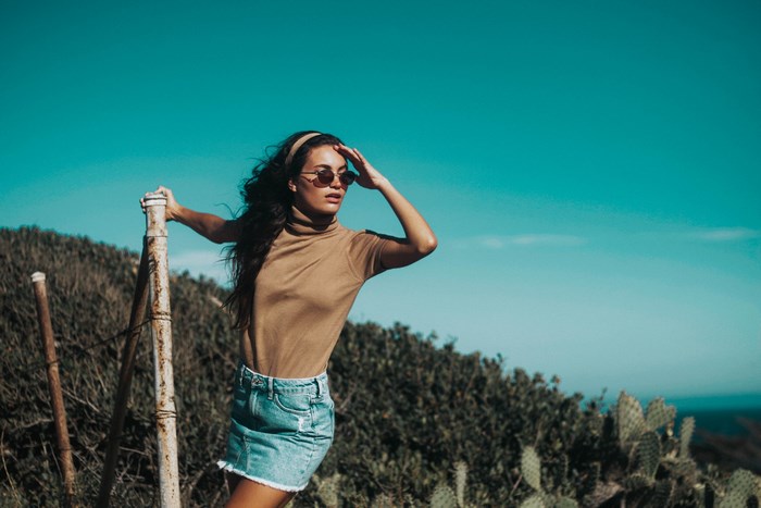Woman in denim skirt and turtleneck on a hillside