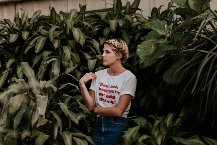 Woman with braided hair in a t-shirt and denim skirt