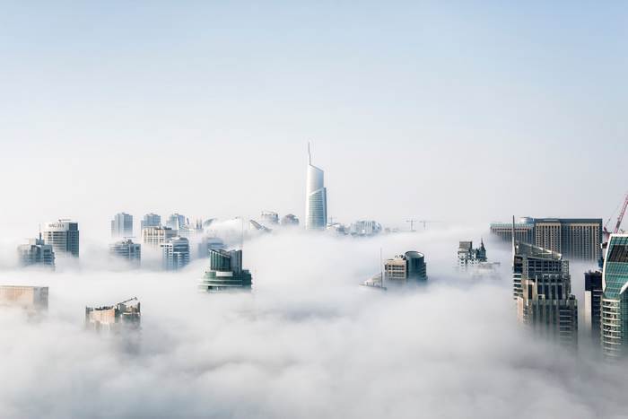 City skyscrapers emerging from thick fog