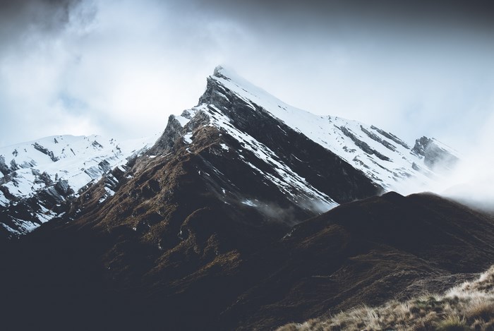 Snow-capped mountain peak with mist and fog