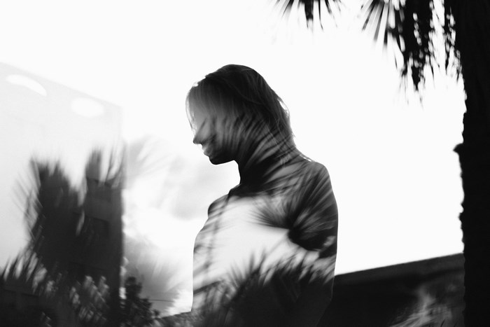 Double exposure of a woman with palm leaves