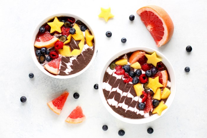 Two smoothie bowls with fruit and star-shaped mango