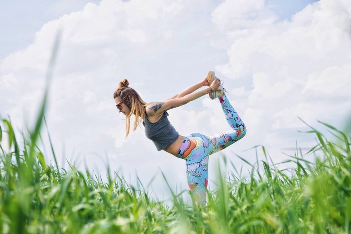 Woman doing yoga in a grassy field