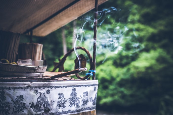 Incense stick smoking on a table outdoors