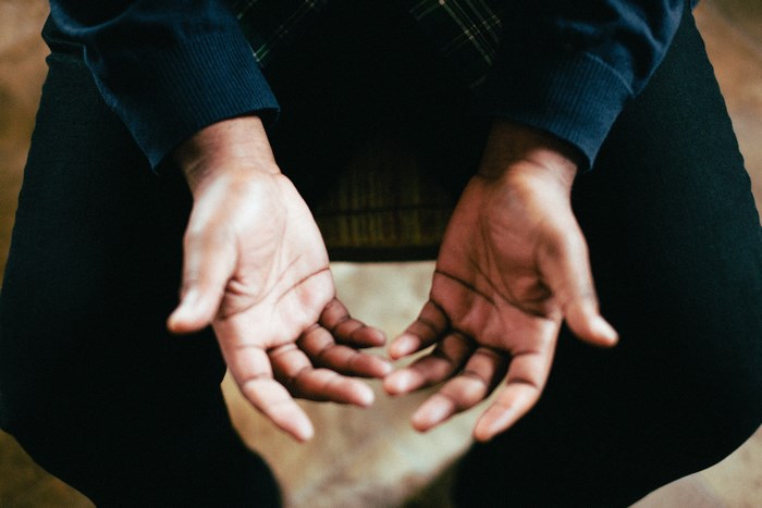 Person with hands open, sitting