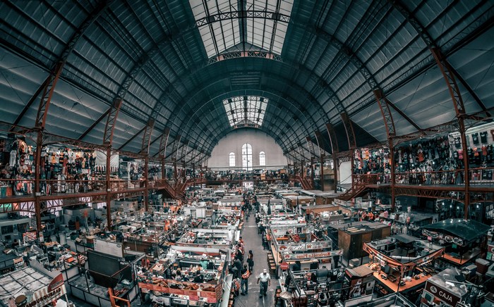Interior of a large market hall with many stalls