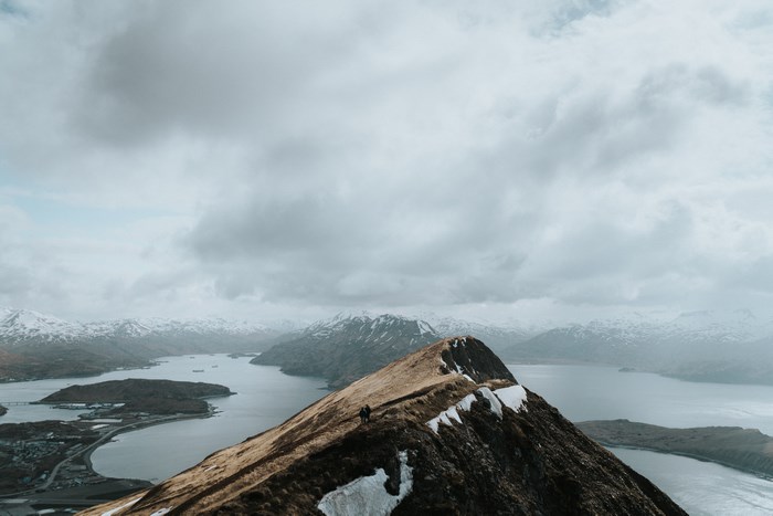 Two hikers on a mountain ridge overlooking a bay