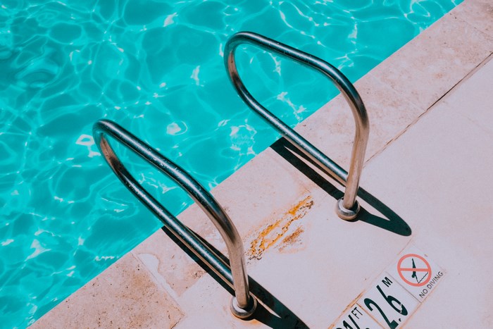 Swimming pool with handrails and no diving sign