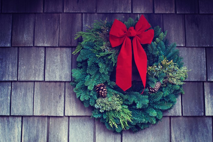 Festive Christmas Wreath with Red Bow on Wooden Wall