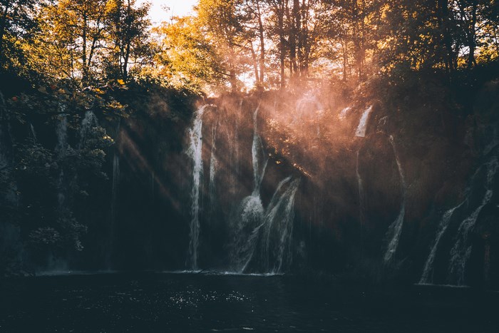 Sunlit Waterfall and Mist in Plitvice Forest