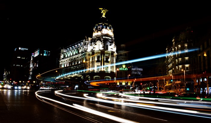 Metropolis building with light trails at night in Madrid
