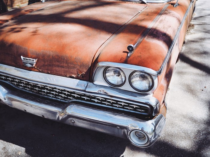 Rusty Orange Ford Car with Chrome Bumper and Grill