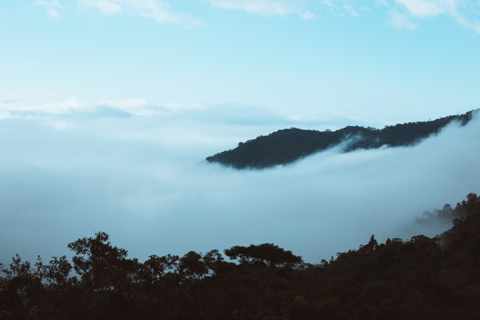Mountain peak emerging from clouds in the morning