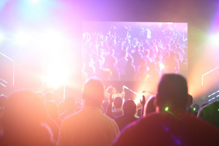 Audience watching a screen at a colorful event