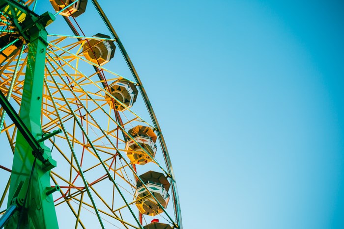 Ferris wheel with colorful lights against a blue sky