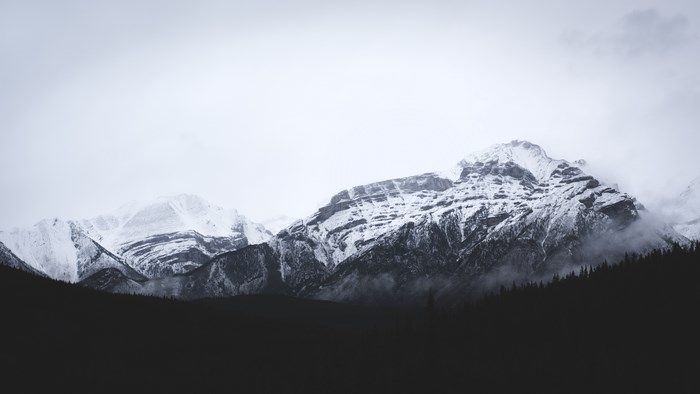 Snow-covered mountains in Banff under a cloudy sky