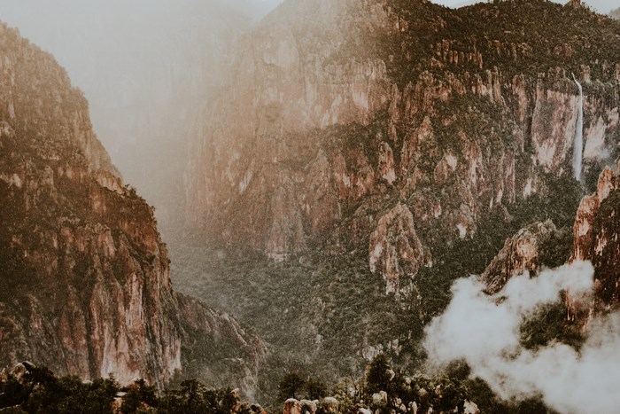 Rainy mountain landscape with cliffs and fog