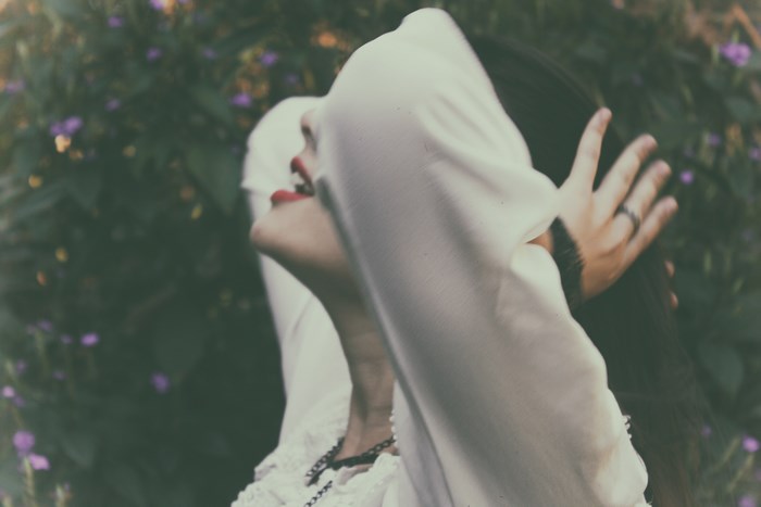 Woman with red lipstick holding her head and hair