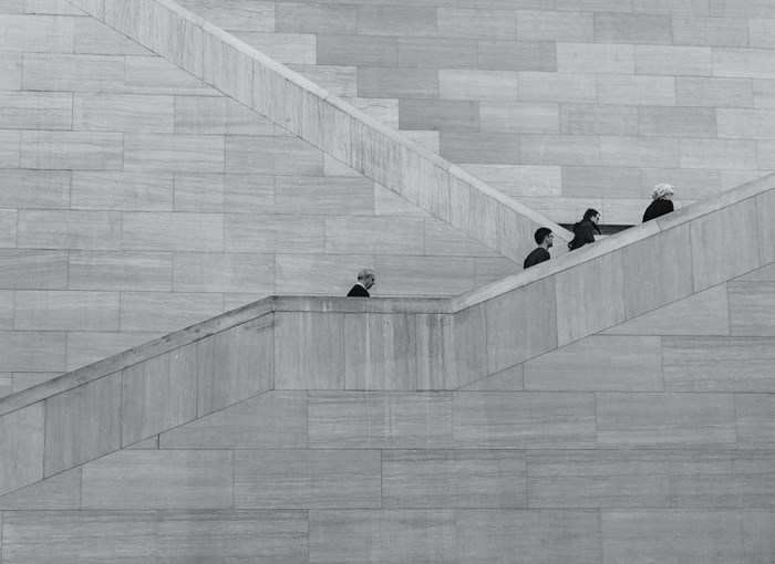 People walking up a modern stone staircase