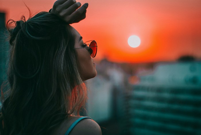 Woman wearing sunglasses at sunset