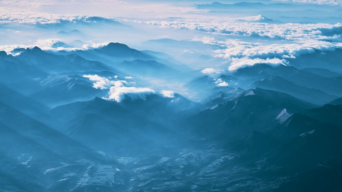 Misty mountain range with clouds and sunbeams