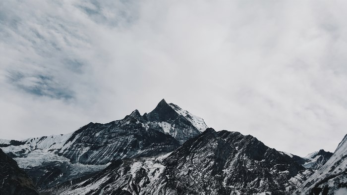 Snow-covered mountain range under a cloudy sky