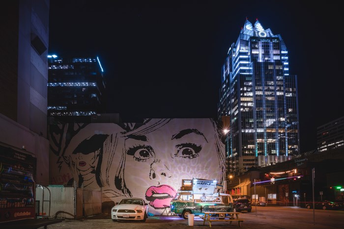 Street art mural of a woman's face at night