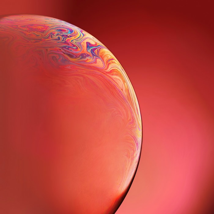 Orange planet with colorful swirls on red background