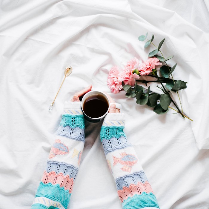 Person holding a cup of coffee with flowers