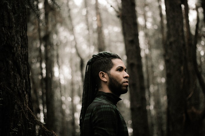 Man with dreadlocks in a forest
