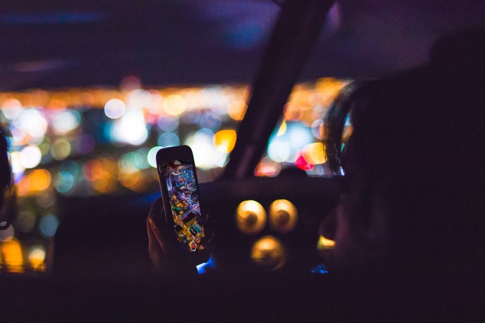 Woman holding iPhone with Las Vegas city lights at night